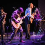 Al-Stewart-and-the- Empty-Pockets- playing-guitar-keyboard-singing-on- stage