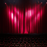 red curtain on stage with theater chairs