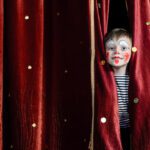 Boy-Clown-Peering-Through-Stage-Curtains